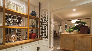 A traditional interior with a wooden cabinet, white doors, and decorative items.