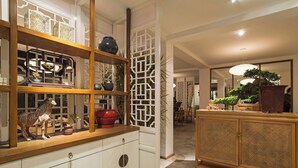 Um interior tradicional com um armário de madeira, portas brancas e objetos decorativos.
