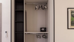 A walk-in closet with open shelves, a hanging rod, and a small radio. - Affittacamere Poerio (Pisa)