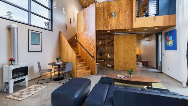 A spacious living area with a fireplace, a staircase, and a loft space with a view.