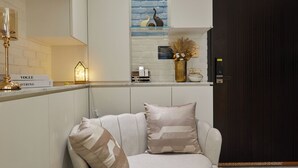 Un salon moderne avec un canapé blanc, une table basse ronde et un vase décoratif.
