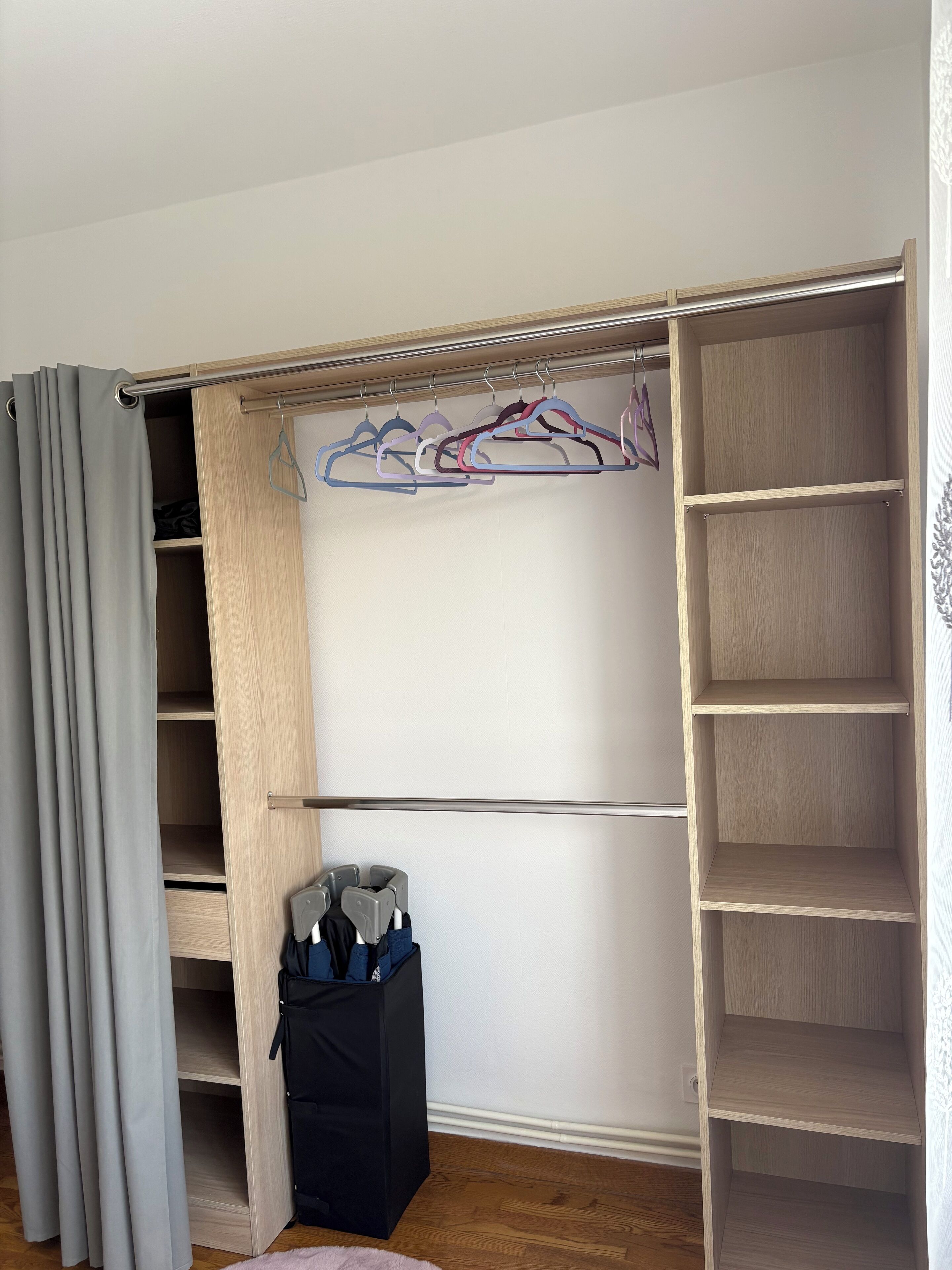 A walk-in closet with multiple shelves and a hanging rod.