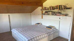 A bedroom with a bed, a bookshelf, and a wardrobe. - Bell Air near Neuchatel (Val-de-Ruz)