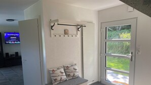 A modern room with a bench, a mounted shelf, and a large window with a view of greenery. - Bell Air near Neuchatel (Val-de-Ruz)