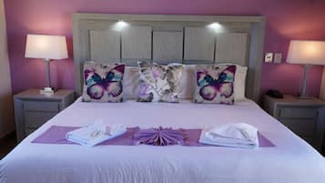 A neatly made bed with a headboard, two bedside lamps, and decorative pillows.