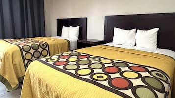 Two twin beds with matching headboards and footboards, each with a white pillow and a yellow bedspread with a circular pattern.