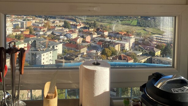A kitchen with a large window overlooking a mountainous landscape and a town below. - Vila across Tepelena (Tepelenë)
