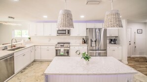 A modern kitchen with white cabinets, a central island, stainless steel appliances, and pendant lighting. - New Listing! Dockside Palms Weeki Wachee-Spring Fed Canal-Boat Friendly!  (Spring Hill)