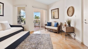 A bedroom with a bed, a sofa, a small table, and a view of the outdoors. - 3-bedroom apartment in perfect Palmas del Mar with pool and beach access (Palmas del Mar)