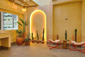 A modern lobby with a large planter, two red wireframe chairs, and a large illuminated wall. - ®{Tulum~Experience}@Downtown +Pool+View+Penthouse (Santo Domingo)