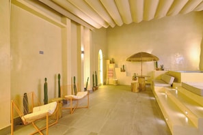 A spa area with a seating area, a massage table, and a large umbrella. - ®{Tulum~Experience}@Downtown +Pool+View+Penthouse (Santo Domingo)