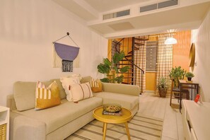A living room with a sofa, a coffee table, a hanging decoration, and a staircase leading to an upper level. - ®{Tulum~Experience}@Downtown +Pool+View+Penthouse (Santo Domingo)