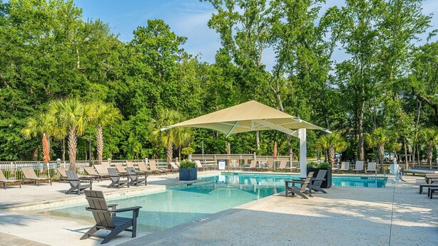 A pool area with lounge chairs and a canopy. - Charming Cottage-resort style pool, pickleball (Hanahan)