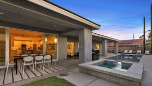 Una casa moderna con un patio, una piscina y un comedor.