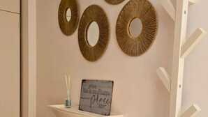 A room with a white cabinet, three circular wall decorations, and a sign with a message.