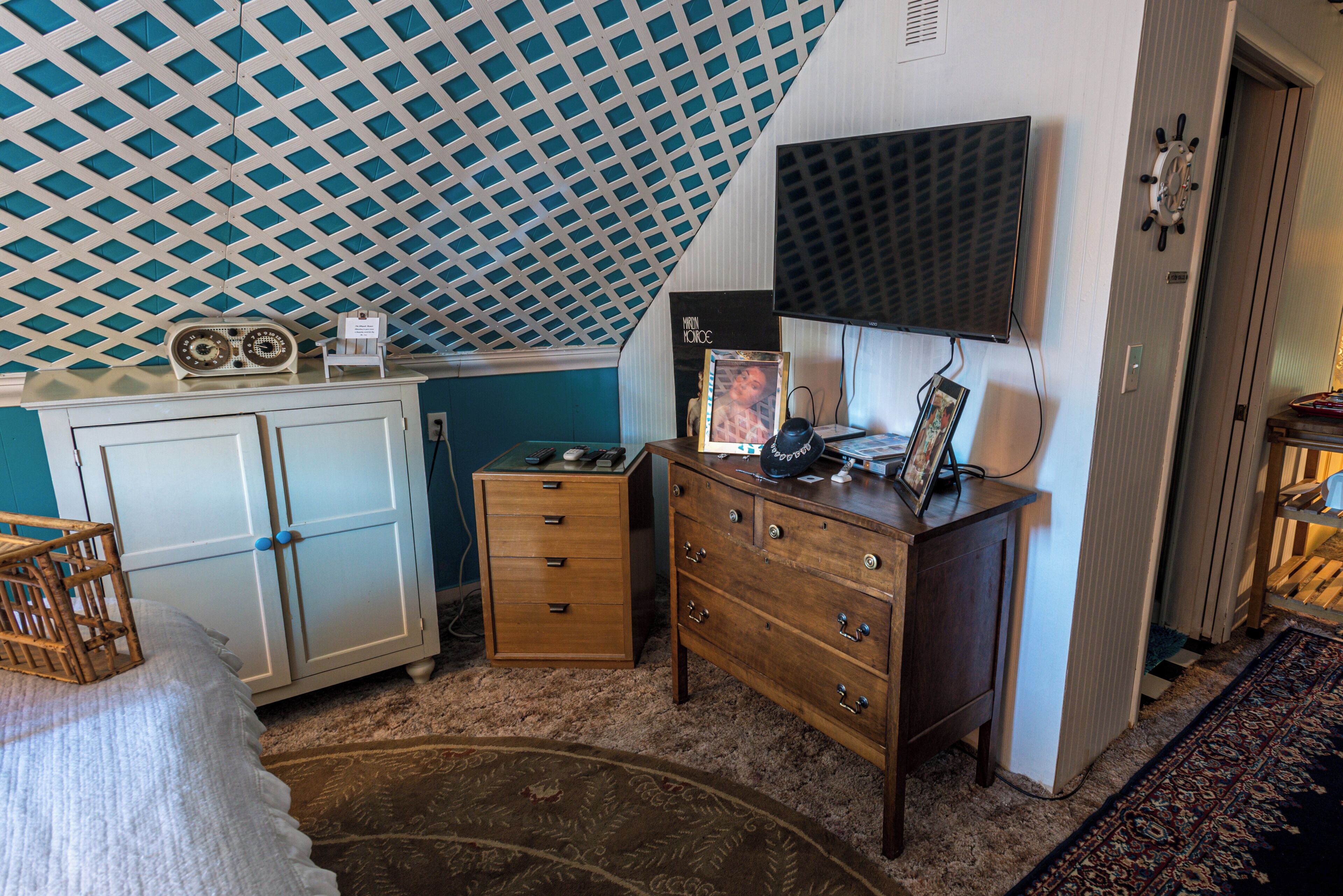 Ein Schlafzimmer mit einem Bett, einem Schminktisch, einem Fernseher und einer raumhaften Decke.