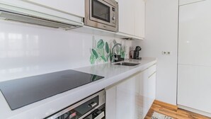 Uma cozinha moderna com micro-ondas, pia e lava-louças.