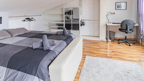 Quarto com cama, escrivaninha e cadeira.