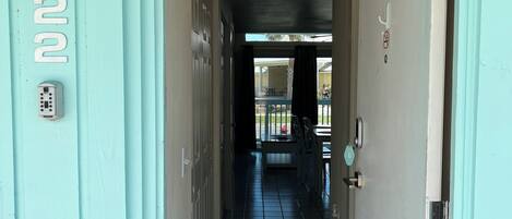 A hallway with a door on the right, a number '122' on the left wall, and a keypad lock.