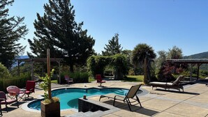 A backyard with a swimming pool, lounge chairs, and a pergola. - Furnished Studio with washer and dryer, and pool! (Ukiah)