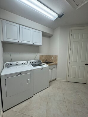 A kitchen with white cabinets, a stove, and a sink.