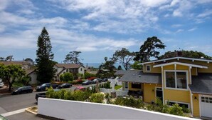 A residential area with houses, a parking lot, and a view of the ocean. - Charming Ocean View 2-bedroom apartment with AC in Del Mar! (Del Mar)