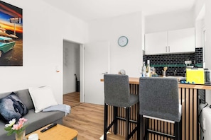 A modern kitchen with a wooden countertop, a clock, and a sink. - MOLA Apartments-Style & Design Wetter Ruhrgebiet (Wetter)