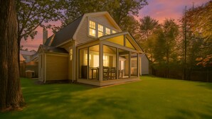 Een huis met een overdekte patio, een garage en een verzorgd gazon.