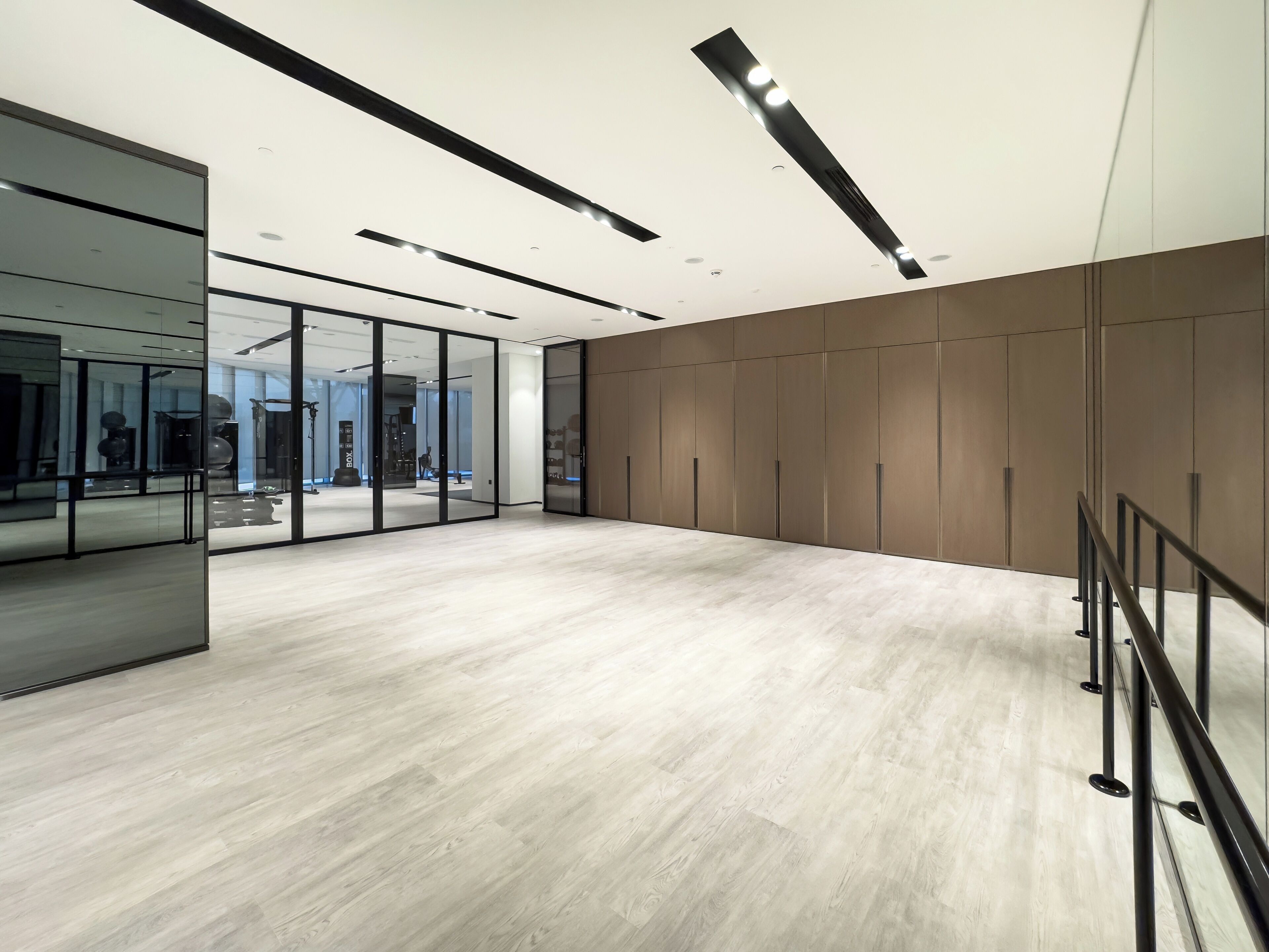Un intérieur spacieux et moderne, avec un plancher en bois clair, des murs en verre et un grand espace de rangement pour les vêtements.