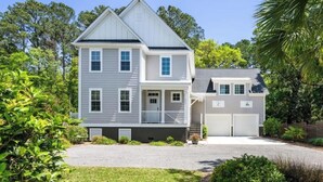 A two-story house with a front porch, a garage, and a driveway. - Homey Place A Short Drive to Downtown & the Beach (Charleston)