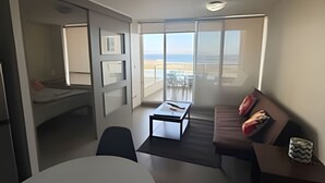 A modern living room with a balcony, a dining table, and a sofa. - Lagoon beach white 311 (La Serena)