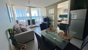 Ein modernes Wohnzimmer mit einem Glastisch, einer Couch und Blick auf den Ozean.