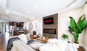Un salon moderne avec un canapé, une table basse et un téléviseur fixé au mur.