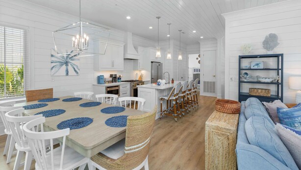 A spacious kitchen with white cabinetry, a central island, and pendant lighting. - Dreamy, Accessible Family Home for 12 (Orange Beach)