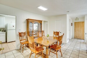 A dining area with a wooden table and chairs, a cabinet, and a refrigerator. - 12 Mi to Dtwn LA: Family Home w/ Patio + Yard! (Downey)