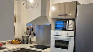 A modern kitchen with stainless steel appliances, a built-in oven, and a microwave. - Appart Anse à l'Ane, Les Trois Ilets, with panoramic view 300 m from the sea (LES TROIS ILETS)