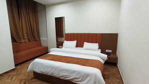 A hotel room with a large bed, a sofa, a nightstand, and a mirror. - Hotel grand Lucent  (Mahaban)