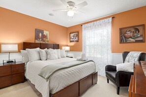 A bedroom with a bed, bedside tables, a chair, a ceiling fan, and artwork on the walls. - Luxury 2850sf Rental | Water + Conservation Views | Near Clubhouse | Gated (Davenport)