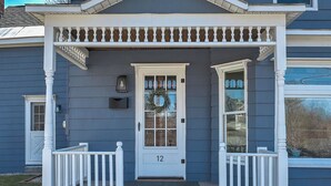 A house with a porch, a front door with a wreath, and a mailbox. - Family-Friendly 3BR Historic Home – Walk to Keene Central Square & Trails! (Keene)