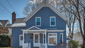 A two-story blue house with a front porch, a chimney, and a number '12' on the door. - Family-Friendly 3BR Historic Home – Walk to Keene Central Square & Trails! (Keene)
