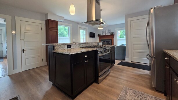 A modern kitchen with granite countertops, stainless steel appliances, and a central island. - Family-Friendly 3BR Historic Home – Walk to Keene Central Square & Trails! (Keene)