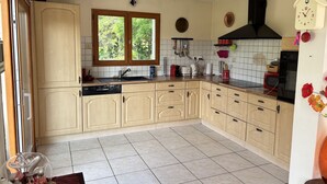 Una cocina con ventana, un fregadero, estufa y microondas.