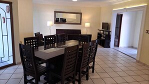 A dining area with a rectangular table and six chairs, a television on a stand, and a mirror on the wall. - HOUSE WITH SWIMMING POOL IN CUAUTLA DOWNTOWN (Cuautla)