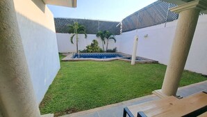 A courtyard with a swimming pool, green lawn, and a tiled patio area. - HOUSE WITH SWIMMING POOL IN CUAUTLA DOWNTOWN (Cuautla)