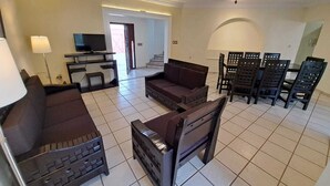 A living room with a sofa, a coffee table, a TV, and a dining area with chairs and a table. - HOUSE WITH SWIMMING POOL IN CUAUTLA DOWNTOWN (Cuautla)