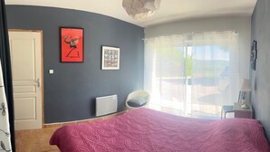 A bedroom with a bed, a chair, a radiator, and a window with blinds. - Family home between the sea and the Cevennes (Calvisson)