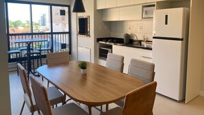 Una cocina moderna con armarios blancos, una encimera negra y un horno empotrado.