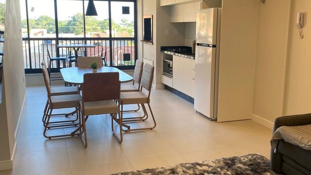 Un apartamento moderno con comedor, cocina y un balcón con vistas.