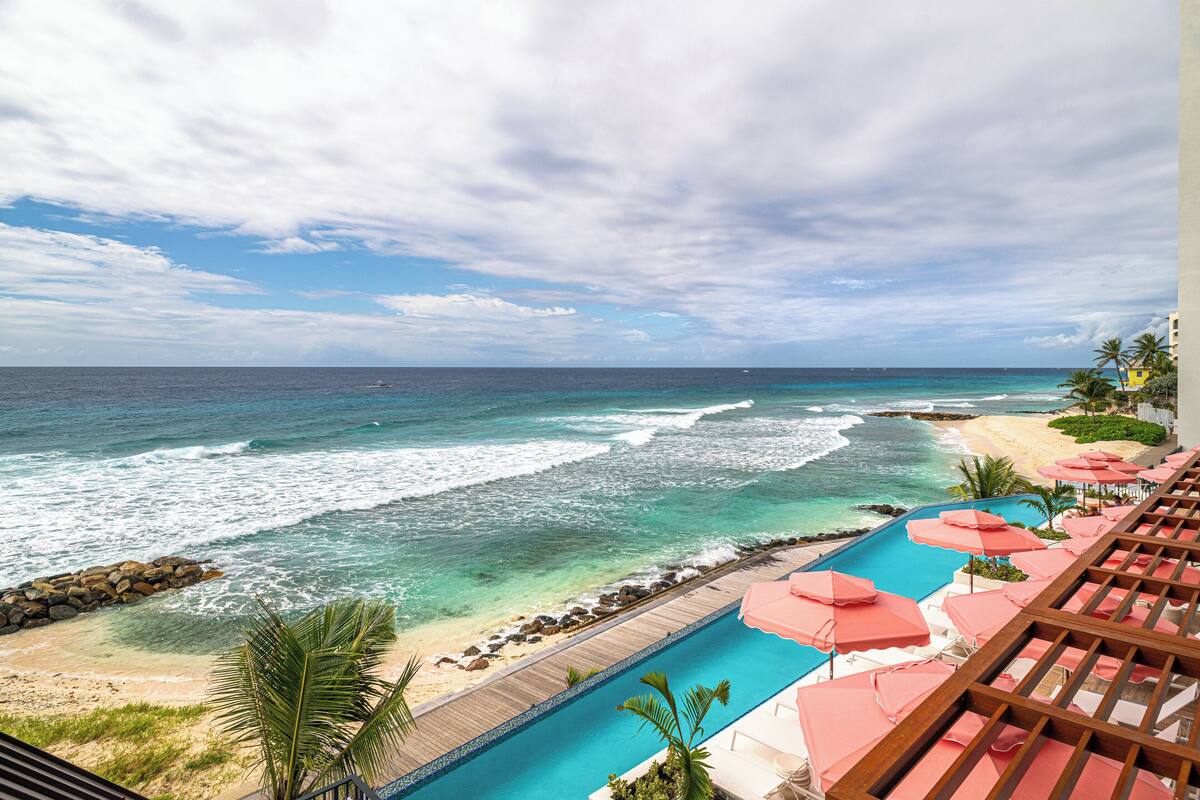 A resort with a pool, beach, and ocean view.
