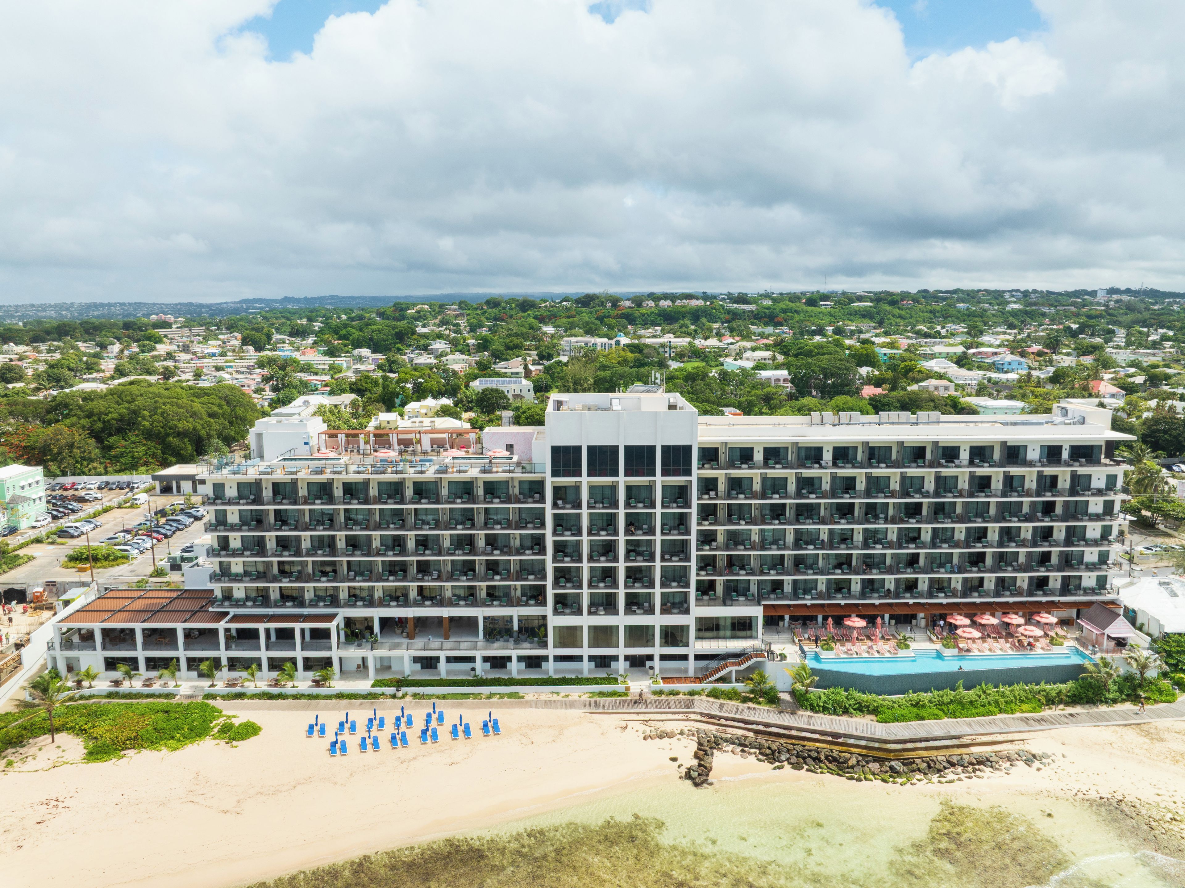Ein mehrstöckiges Hotel mit Pool und Strand.